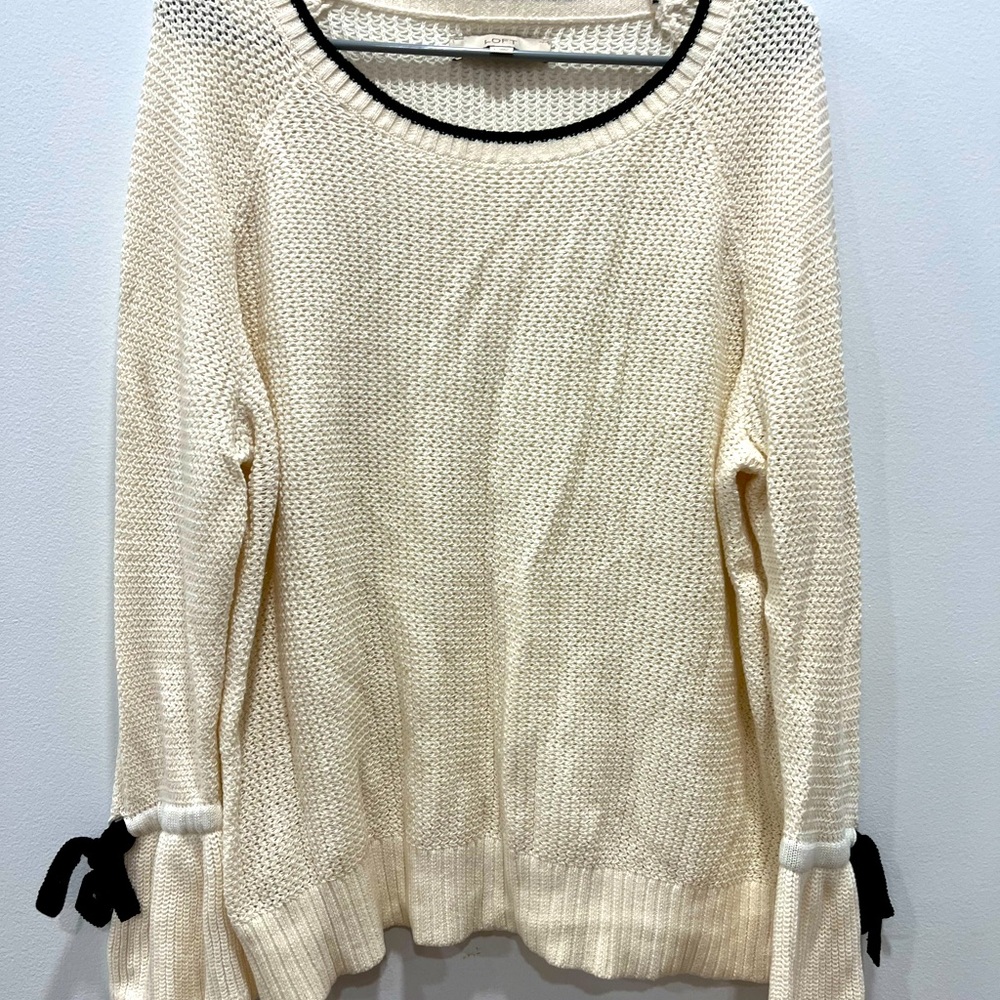Worn once - cream sweater with trumpet sleeves and black bows at the cuffs.
